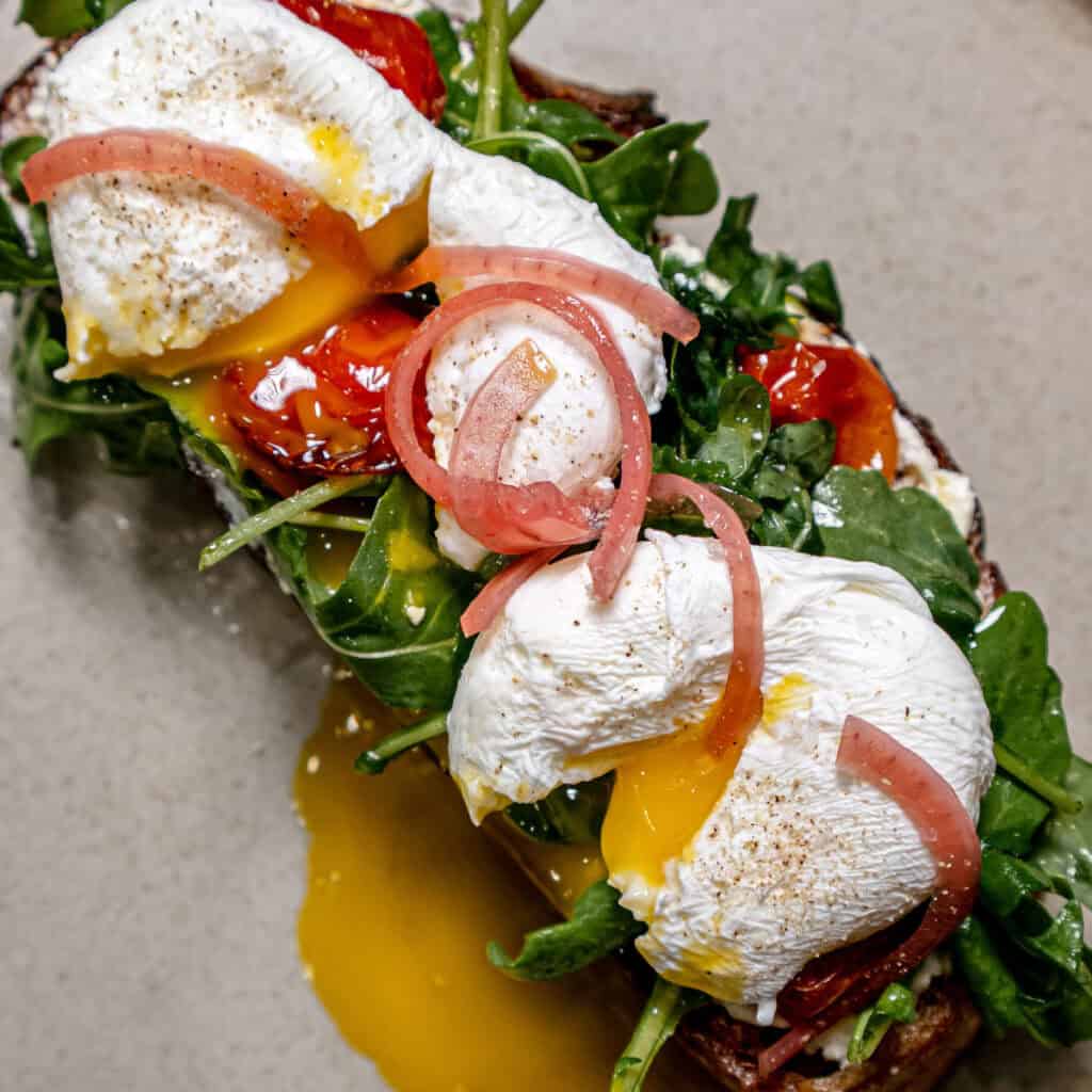 Sourdough Toast w/ Whipped Feta, Tomato Confit, Poached Egg, & Pickled Onions