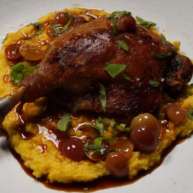 Classic Duck Confit w/ Crispy Potatoes, Fresh Corn Polenta, and Charred Grape Agrodolce