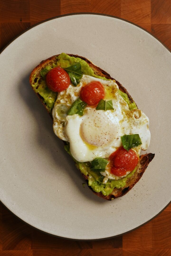 Avocado toast with tomato confit, a crispy fried egg, and a raw drizzle of Bona Furtuna Everyday olive oil