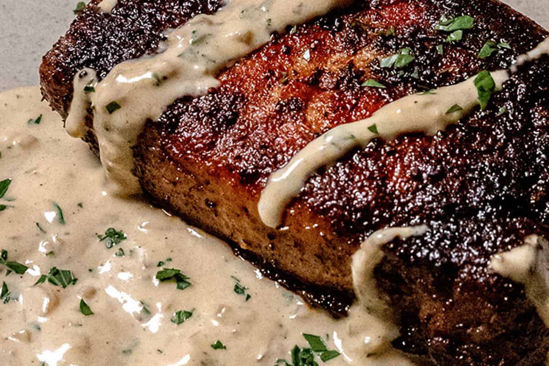 A seared pork chop under a creamy mustard pan sauce, built with a splash of alcohol cooked off.